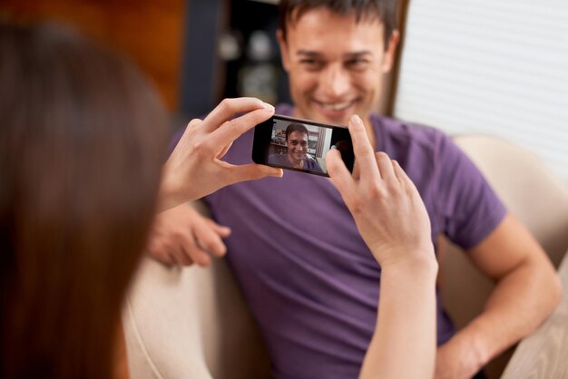 Fotografie telefoonscherm en koppel in het huis gelukkig binden en plezier hebben samen Smartphone profielfoto en vrouw met foto-app of romantische herinnering aan man terwijl ze zich ontspannen in de woonkamer