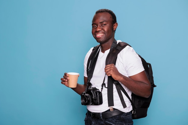 Fotografieliefhebber die op stedentrip gaat terwijl hij een reistas en DSLR-camera heeft. Gelukkige professionele fotograaf met rugzak en camera klaar voor vakantiereis.