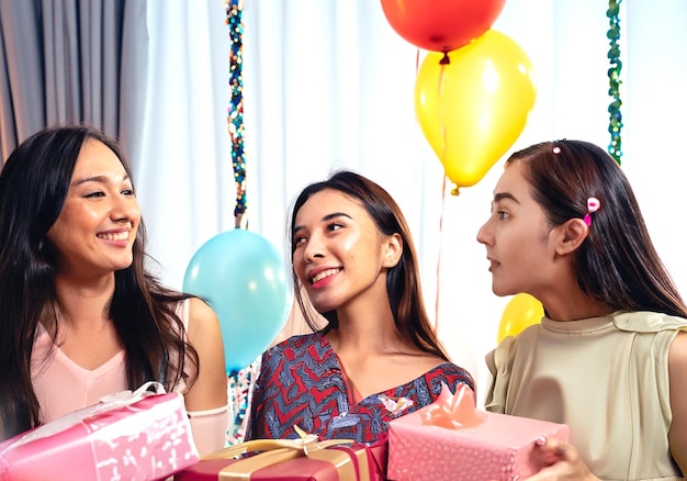 fotogroep van drie vriendinnen die genieten van het feest met cadeautjes en ballonnen