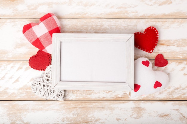 Fotolijstje tussen Valentijnsdag romantisch decoreren met verschillende harten op een witte houten tafel