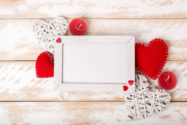 Fotolijstje tussen Valentijnsdag romantische decoratie met hart en kaars op een witte houten tafel