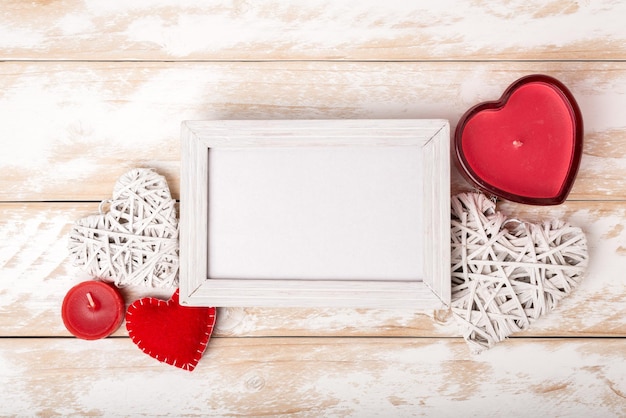 Fotolijstje tussen Valentijnsdag romantische decoratie met hart en kaars op een witte houten tafel