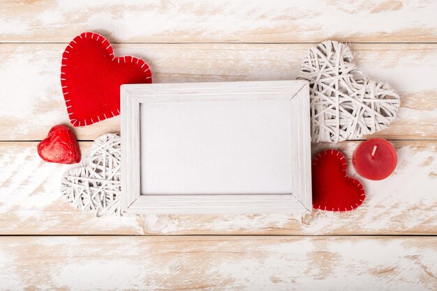 Fotolijstje tussen valentijnsdag romantische decoratie met harten kaars op een witte houten tafel