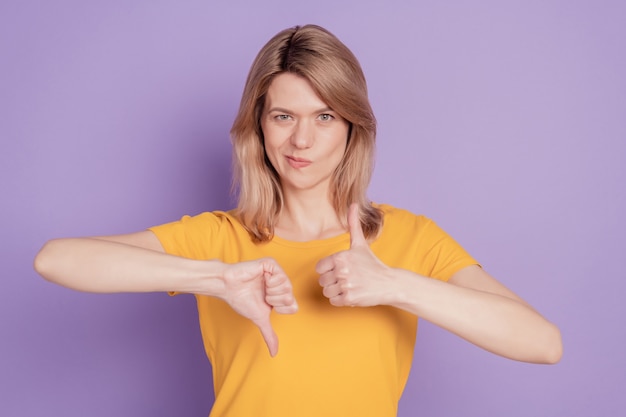 Fotoportret van een vrouw die duim omhoog toont en besluit besluit teken geïsoleerd op violet gekleurde achtergrond