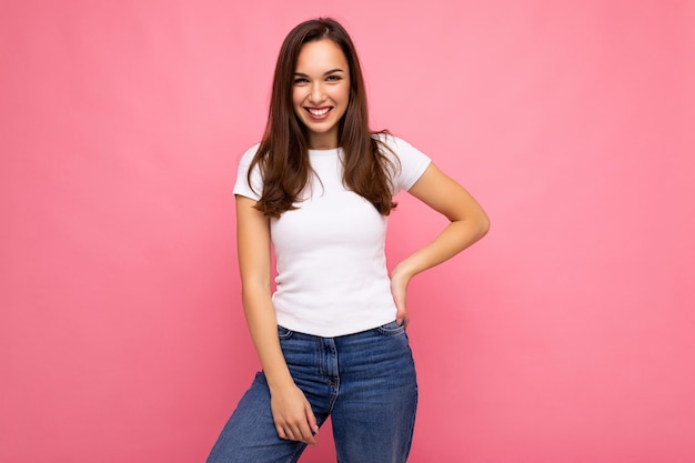 Fotoportret van jonge mooie glimlachende hipster donkerbruine vrouw in witte t-shirt