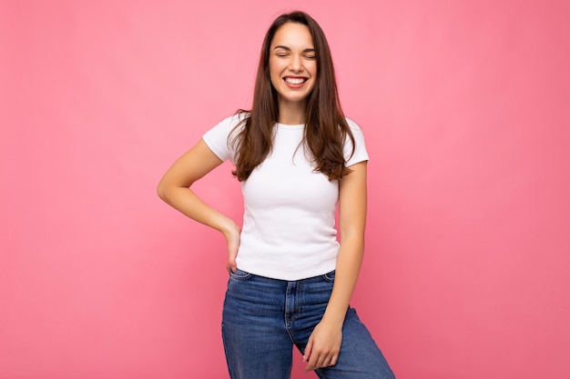 Fotoportret van jonge mooie glimlachende hipster donkerbruine vrouw in witte t-shirt