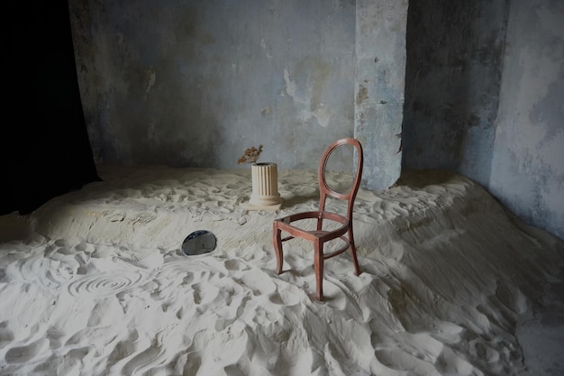 Fotostudio in de stijl van minimalisme met zand oude muren en een stoel zonder zitje de tijd van verdriet is voorbij