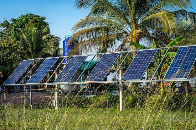 Fotovoltaïsch zonne-energiepaneel voor landbouw in een landelijke huizengebied agrarische velden blauwe hemelachtergrondagro-industrie van huishouden landelijke stijl in thailand slimme boerderij alternatieve schone energie