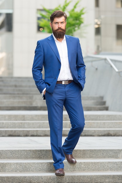 Founder successful business. Conquer business world. Bearded man going to work. Business man in modern city. Beginning of working day. Motivated for success. Office worker confidently step on stairs.