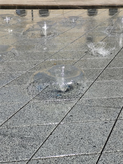 A fountain on a gray ceramic tile with lights turned off for illumination