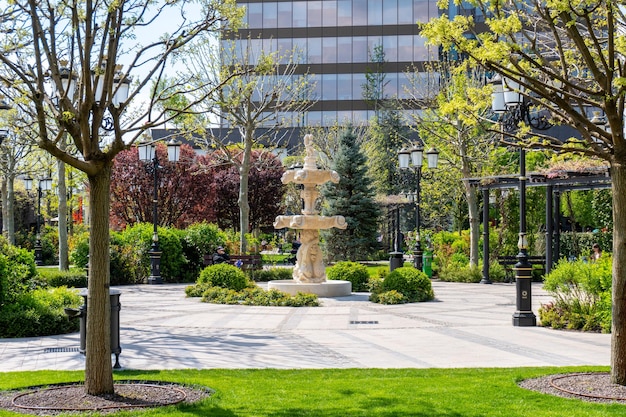A fountain in a park with a building in the background