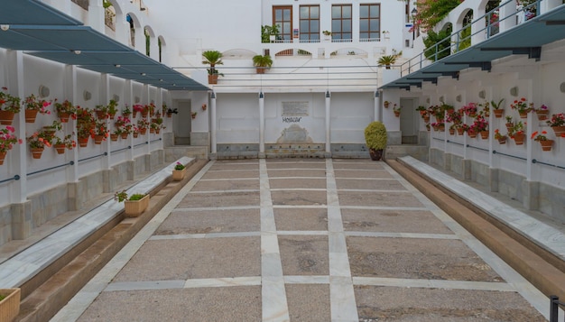 Fountain patio with white walls and ornamental pots with geraniums Mojacar