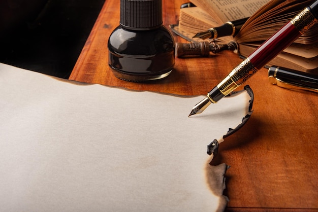 Fountain pen a beautiful fountain pen a blank sheet with burnt\
edges on a rustic wooden surface selective focus