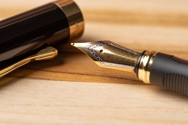 Перьевая ручка, красивая перьевая ручка, расположенная на деревенской деревянной поверхности, выборочный фокус.