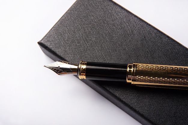 Photo fountain pen beautiful golden fountain pen over dark box on white background selective focus