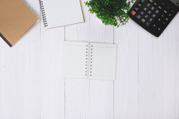 Fountain pen or ink pen with notebook paper and calculator on wood