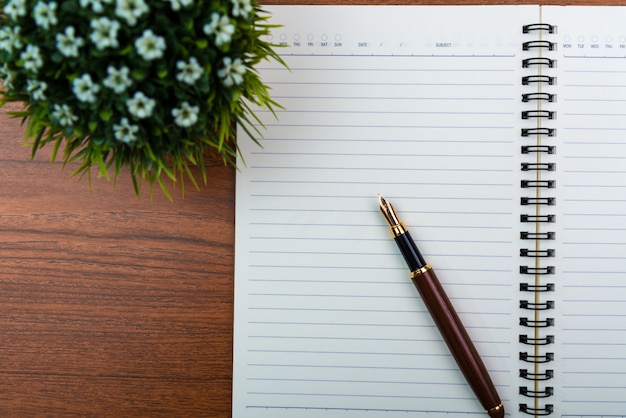 Fountain pen or ink pen with notebook paper and little decoration tree