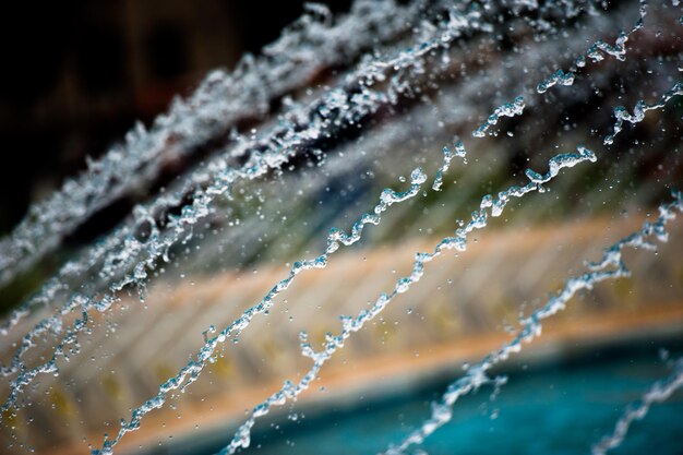 Fountain water jets with a blurry background.