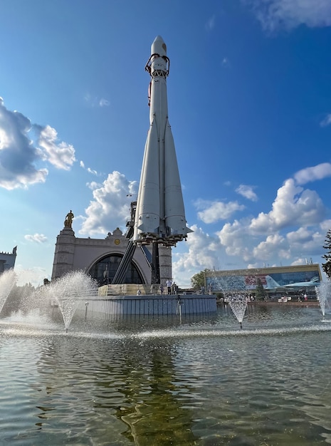 A fountain with a clock on it and a fountain in the background.