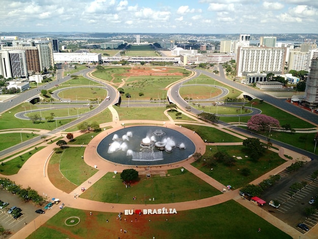 Fountains in park by buildings in city against sky