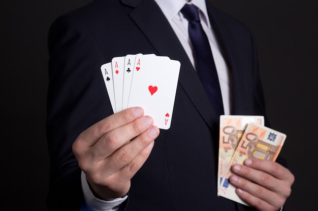 Four aces cards and euro banknotes in mans hands