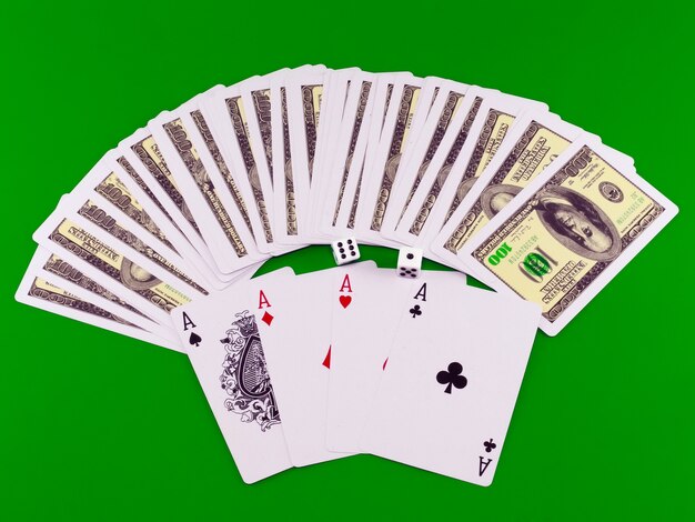 Four aces and dice on green broadcloth (background).