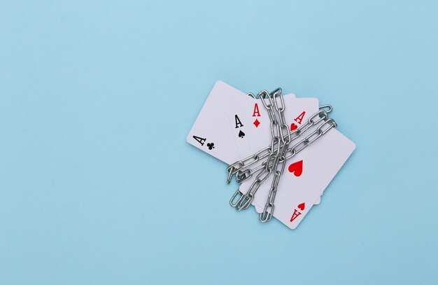 Quattro assi avvolti in una catena d'acciaio su sfondo blu. divieto di attività di gioco d'azzardo, casinò