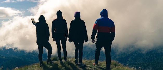 Foto le quattro persone attive in piedi sulla montagna con una bellissima vista