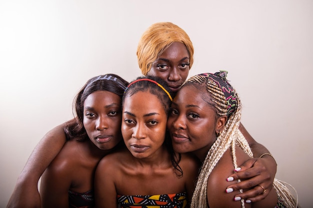 Four African women with serious expressions look towards the camera studio shot with copy space