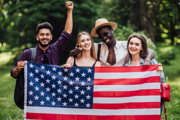 Four american students with flag in uneversity at campus