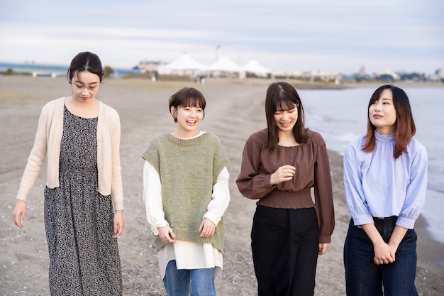 写真 夕暮れ時に楽しく話している4人のアジアの若い女性