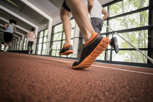 Quattro donne e uomini atletici che corrono sulla pista di atletica