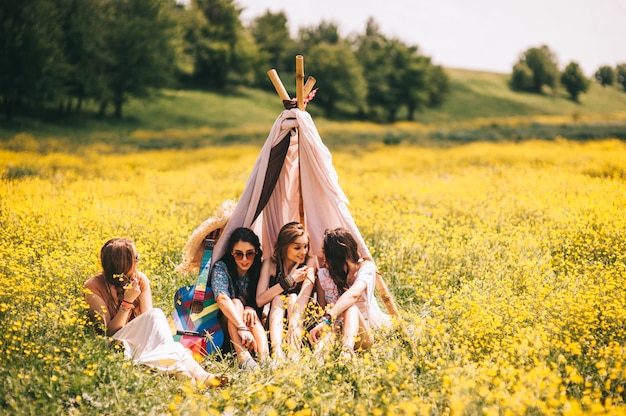 четыре красивые хиппи девушка в поле из желтых цветов