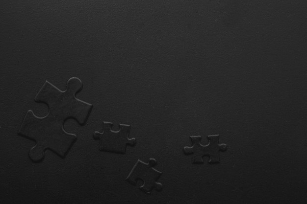Four black puzzles on a dark background