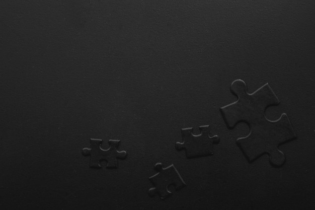 Four black puzzles on a dark background