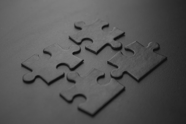 Four black puzzles on a dark background