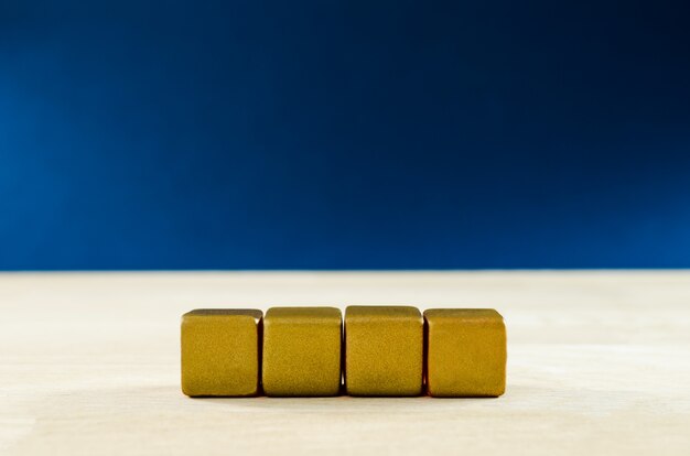 Photo four blank golden blocks placed in a row