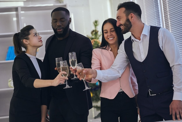 The four business people clink glasses