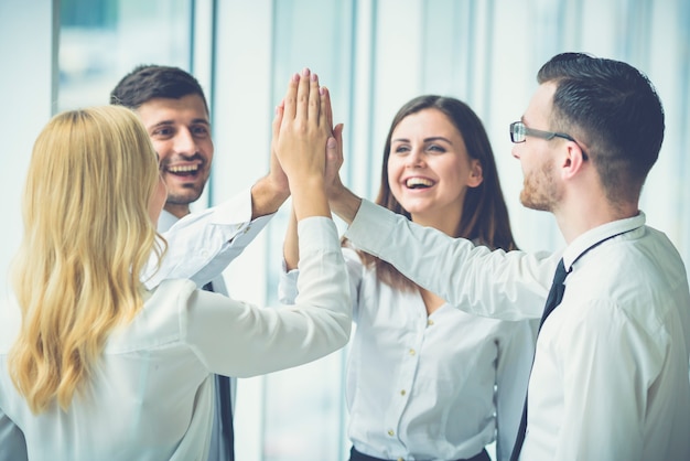 The four business people greeting with a high five