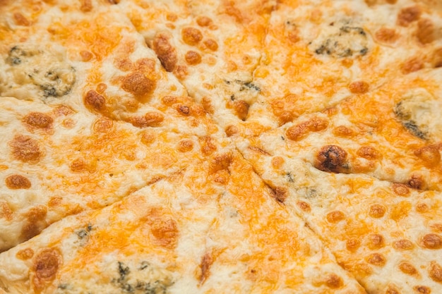 Pizza ai quattro formaggi tagliata in 8 parti di sfondo alimentare