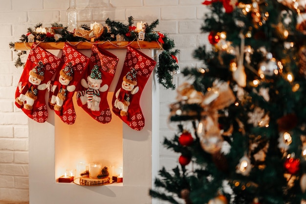 Four Christmas red socks hanging on white fireplace in room