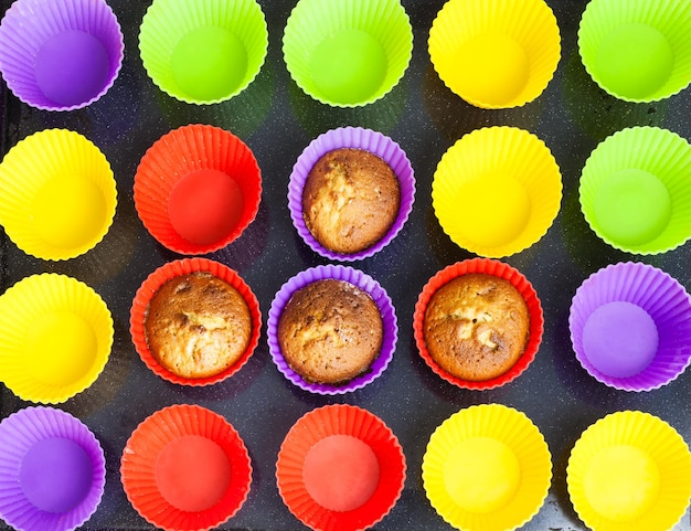 Foto quattro cupcakes e tanti stampini multicolori vuoti