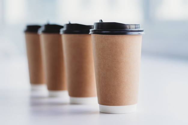 Quattro tazze di caffè sono disposte in fila sul tavolo