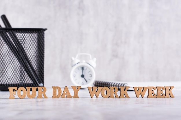 Photo four day work week word from wooden letters on desktop