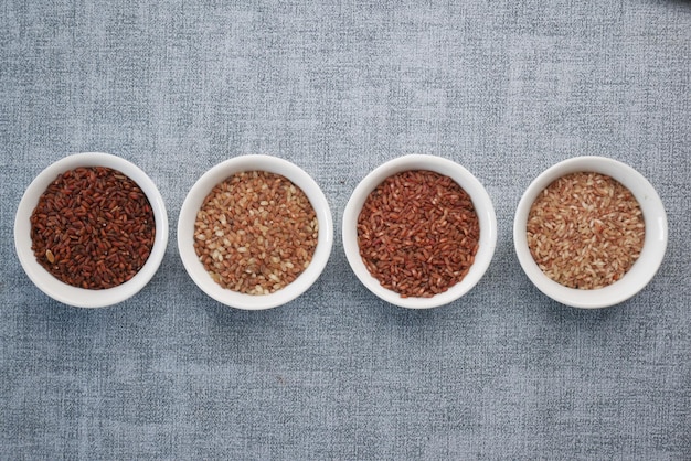 Four different types of rice in a bowl on gray background