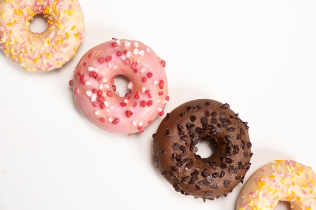 Four donuts in a row white pink and chocolate