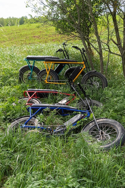 Four electric fat bikes lie in the grass