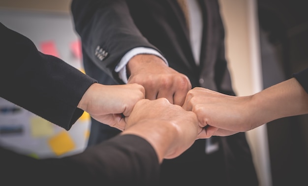 Four Fist bump in business meeting for team concept