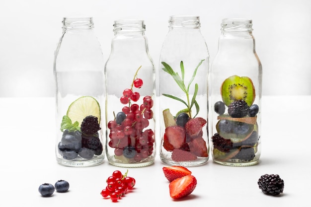 Four glass bottles with berries Berries on the table