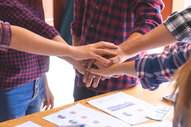 Four hand together in business meeting for team concept